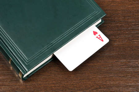Book and ace card on deskの写真素材