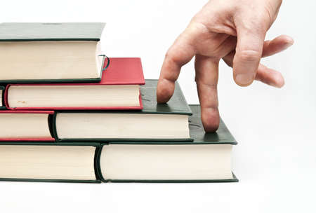 Finger climbing books on whiteの写真素材