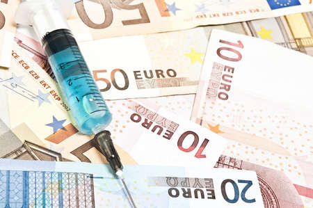 Syringe on many euro banknotesの写真素材