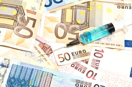 Syringe on many euro banknotesの写真素材