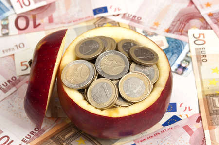 Many coins inside red appleの写真素材
