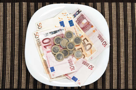 Serving euro banknotes in white plateの写真素材