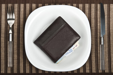 Wallet on plate with fork and knifeの写真素材