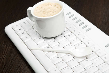 Coffee on an white keyboardの写真素材