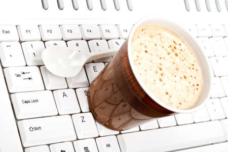 Coffee on an white keyboardの写真素材