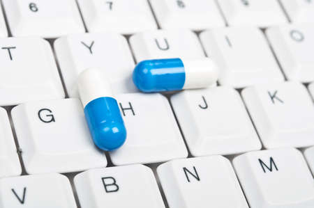 Pills on an white keyboardの写真素材