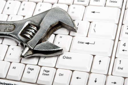 Hand tool on an white keyboardの写真素材