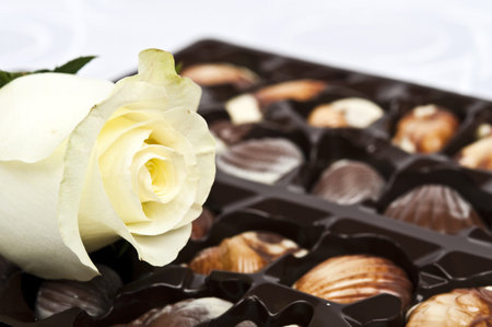Rose and chocolate on white silkの写真素材