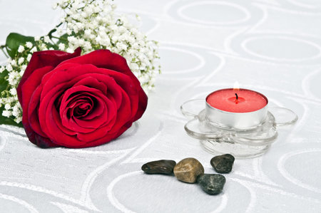 Rose and candle on white silkの写真素材
