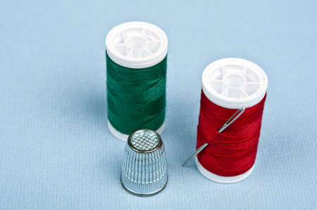 Thimble and thread on blue materialの写真素材