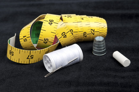 Thread and thimble on black material