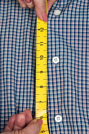 Tailor hands measuring blue shirtの写真素材