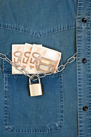 Jeans shirt pocket with money and padlockの写真素材