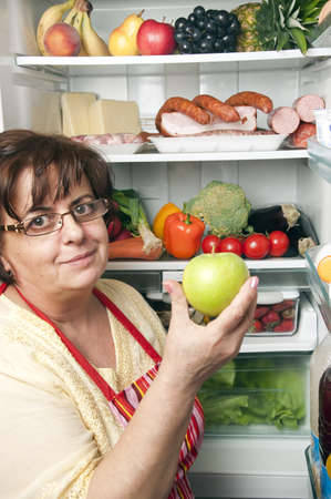 Refrigerator close up with mature womanの写真素材