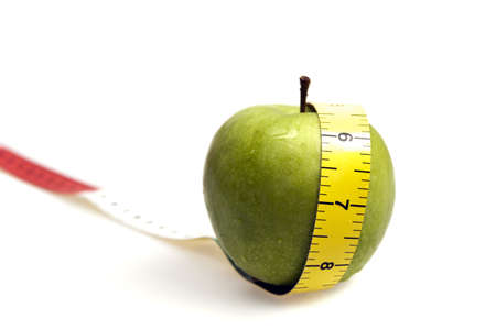 Measurement tape  and apple on whiteの写真素材