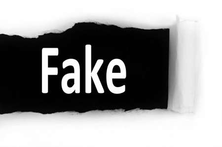 Fake word discovered under paperの写真素材