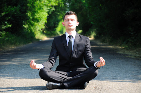 Business man relaxing on roadの写真素材