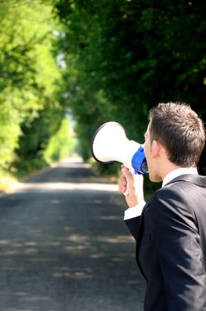 Business man with loudspeaker on roadの写真素材