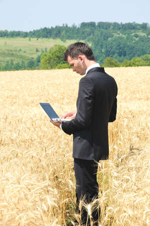 Business man with notebook on fieldの写真素材
