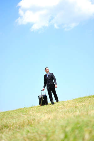 Business man with luggage in natureの写真素材