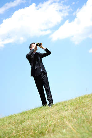 Business man with spyglass in natureの写真素材
