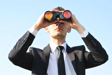 Business man with binoculars on skyの写真素材