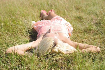 Young girl sit on grassの写真素材
