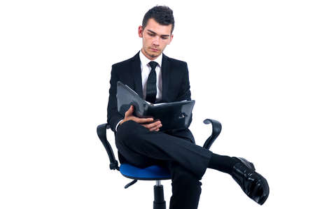 Isolated young business man readingの写真素材
