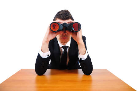 Isolated business man with binocular at desk の写真素材