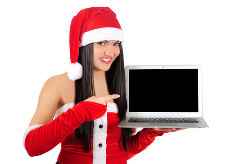 Isolated young christmas girl pointing laptopの写真素材