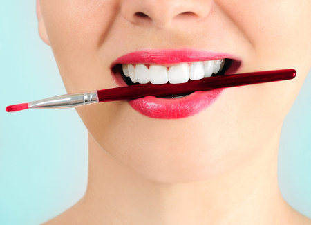 Woman with makeup brush on blue background 
