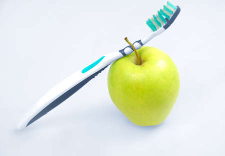 Apple with tooth brush on grey background の写真素材