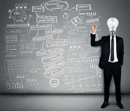 Bulb head business man writing business planの写真素材