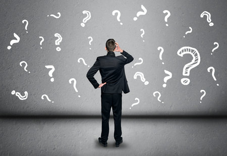 Young business man write question mark on blackboardの写真素材