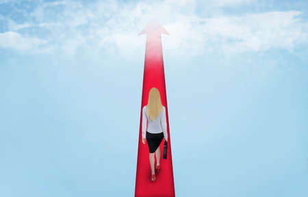 Sky road arrow and business woman walkの写真素材