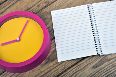 Yellow clock on wooden table