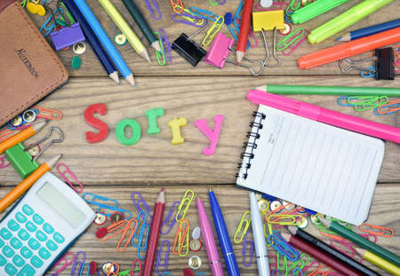 Sorry word and office tools on wooden tableの写真素材