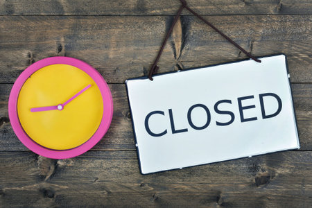 Clock and closed message on wooden table
