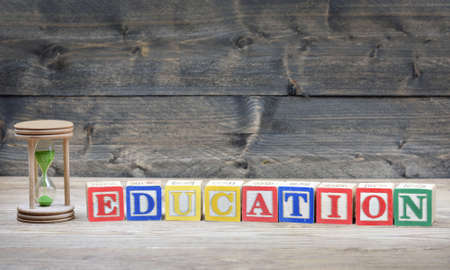 Hourglass and word education on wooden tableの写真素材
