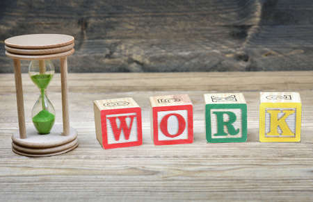 Hourglass and word work on wooden table