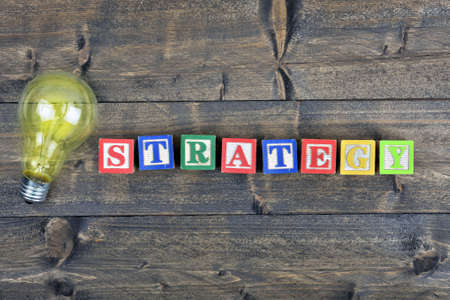 Bulb and word Strategy on wooden tableの写真素材
