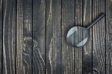 Magnifying glass on wooden tableの写真素材