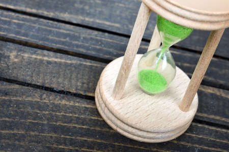 Hourglass close-up on wooden tableの写真素材