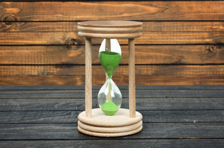 Hourglass close-up on wooden tableの写真素材