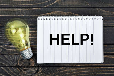 Help text on notepad and light bulbの写真素材