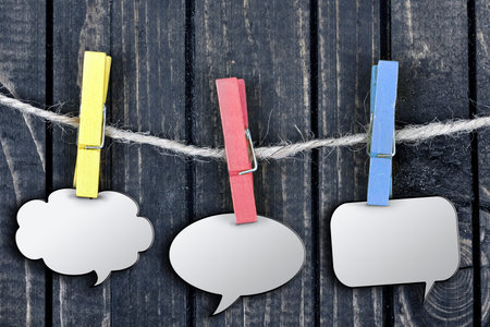 Chat bubbles hanging on clips and wooden wall