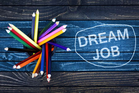 Dream Job text painted and group of pencils on wooden tableの写真素材
