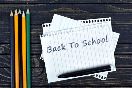Back to school text on notepad and office tools on wooden tableの写真素材