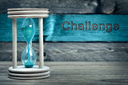 Challenge text and hourglass on wooden tableの写真素材