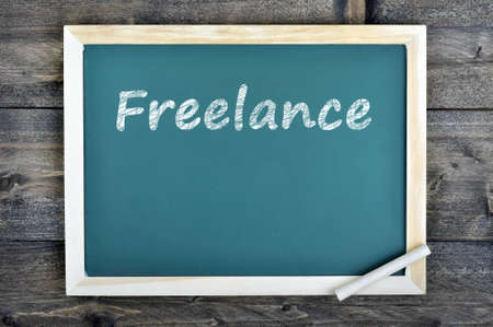 Freelance text on school board and chalk on wooden tableの写真素材